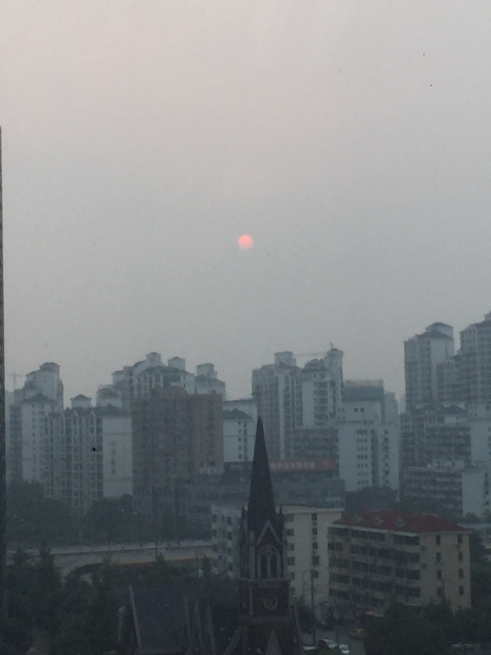 The sun setting over planet Tatouine Shanghai in the smog.